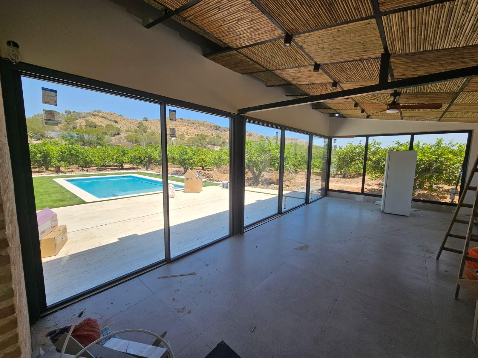 Vista interior del pabellón acristalado hacia el jardín