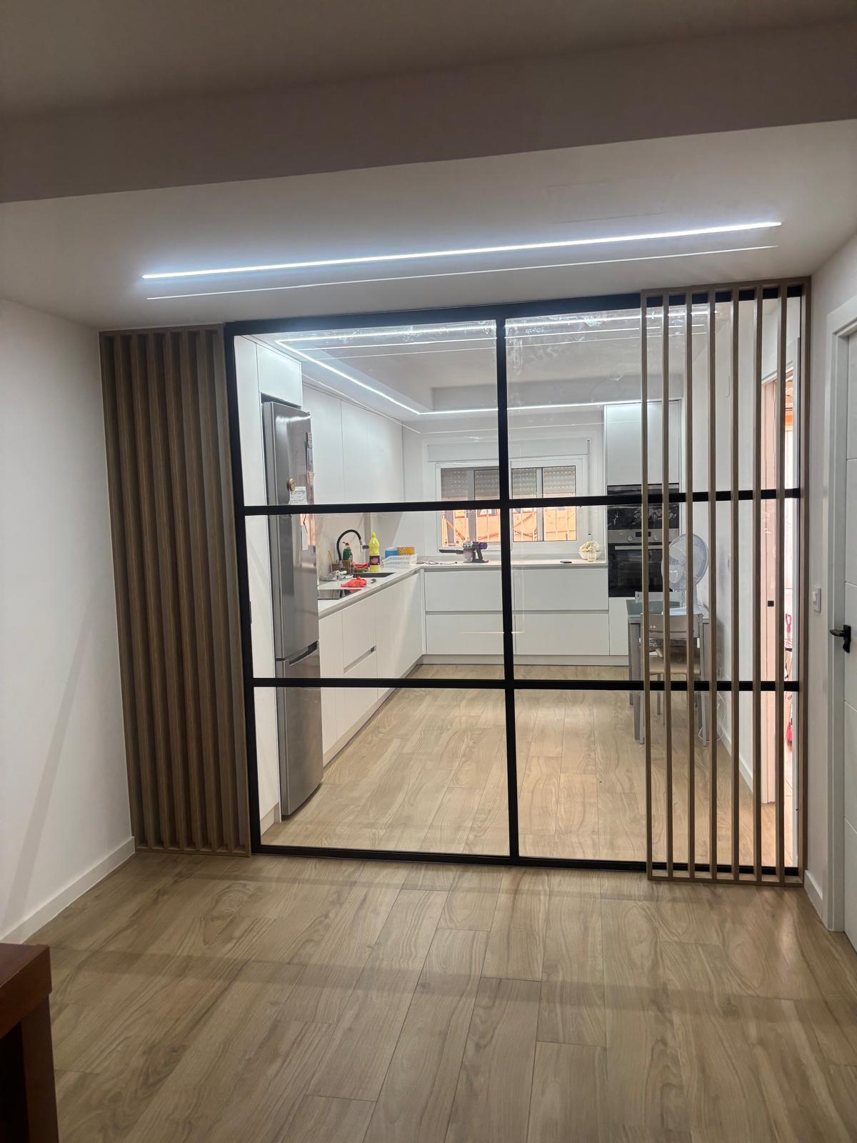 Vista frontal de la división interior abierta hacia la cocina
