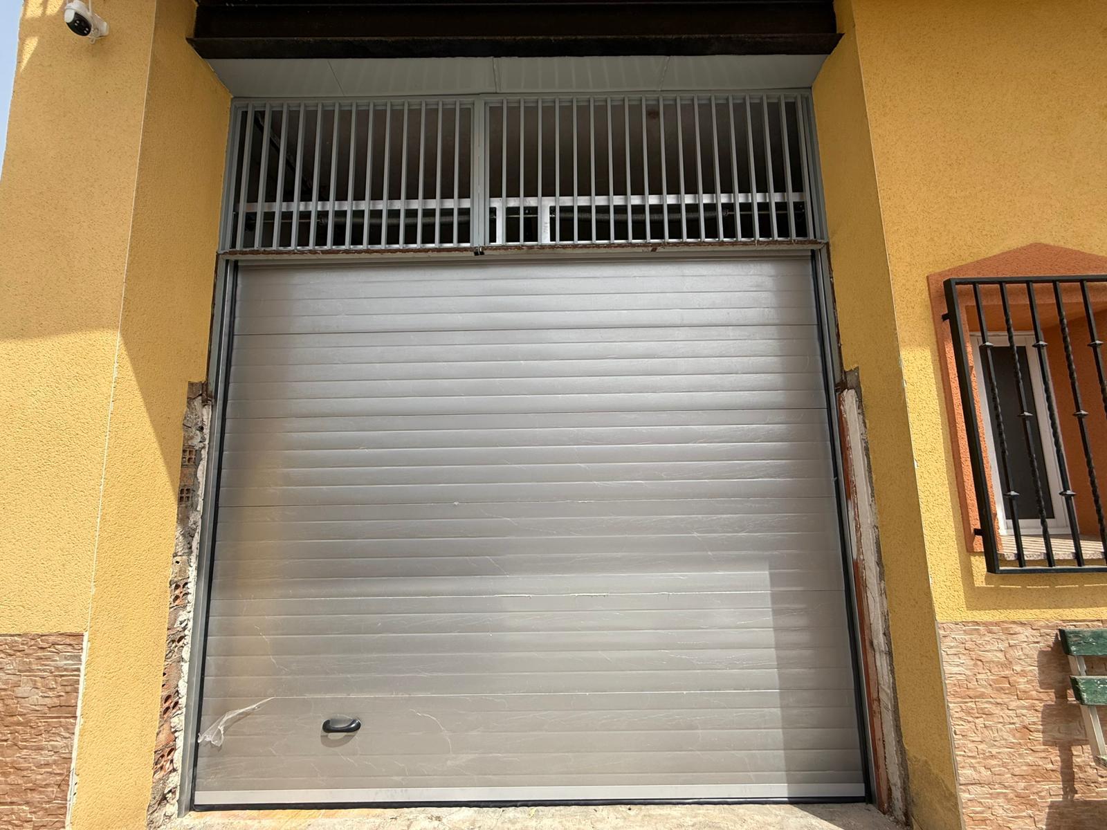 Puerta de garaje instalada en la fachada de una vivienda
