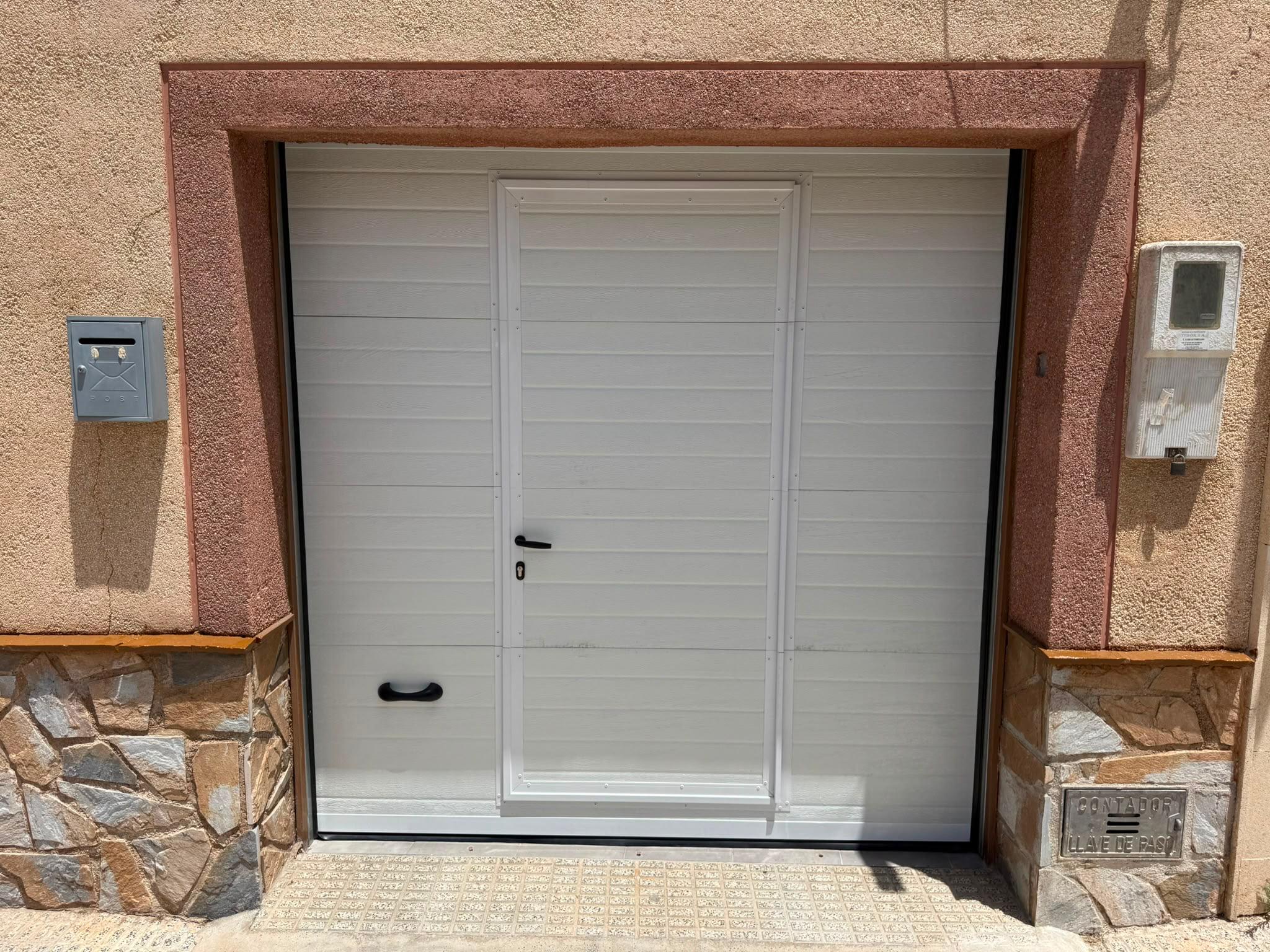 Puerta de garaje con acceso peatonal en una vivienda de Murcia